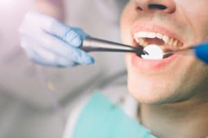 Portrait of a dentist who treats teeth of young man patient.