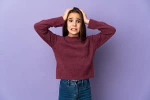 Little girl isolated on purple background doing nervous gesture
