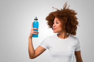 young fitness afro woman drinking an energy drink