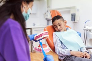 Doctor dentist teaching a child to brush teeth. Dentist concept.