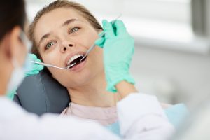Portrait of beautiful young woman in dental chair during medical check up, copy space