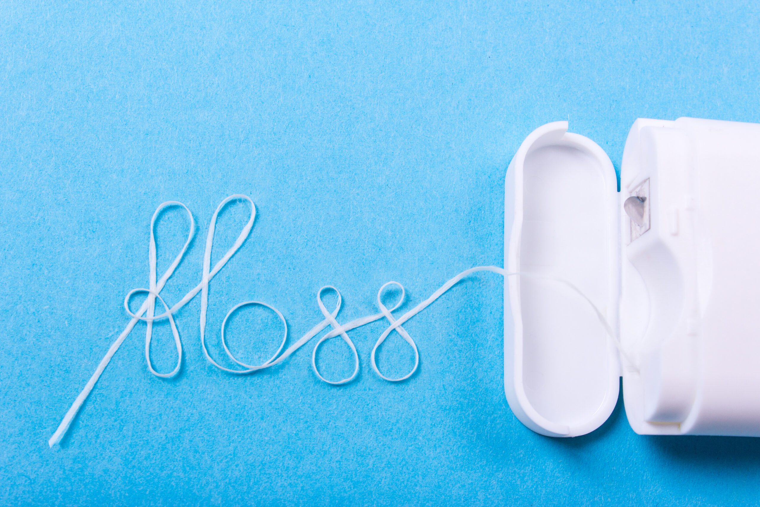 Dental floss word written in letters of floss on a blue background